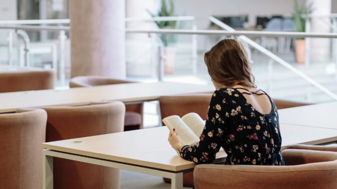 Lány a könyvtárban olvas